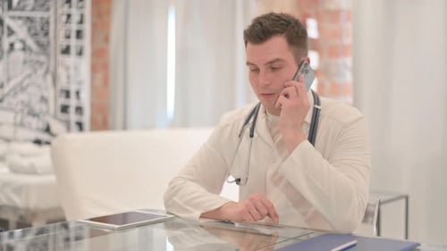 Male Doctor Talking on Phone in Clinic