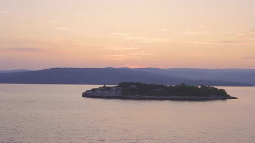 Sunrise, sunset over Adriatic sea with land in the background. Calm water. Camera moves from right t