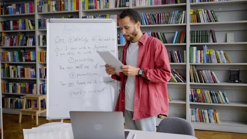 Hübscher Universitätsstudent steht neben dem Flipchart und besteht die Online-Prüfung per Videolink