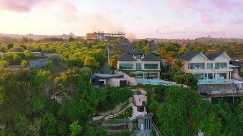 aerial of beachfront luxury homes on Uluwatu Cliffs in Bali Indonesia at sunset