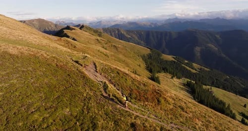 Hiker's Summit Quest With A Sweeping Panorama Of Mountain Ranges