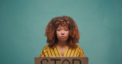 Woman Protests Racism in Studio with Sign