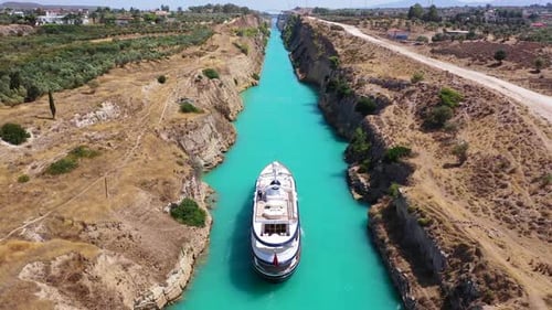 Aerial drone video of yacht crossing famous narrow Corinthian gulf canal known as Isthmus from Saron