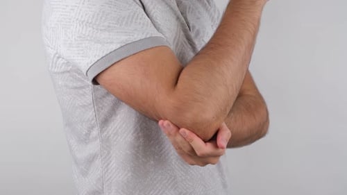 Man Rubbing Elbow in Close Up Shot