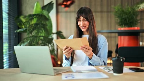 Cheerful Businesswoman Reacting with Joy to Positive News Received in an Office