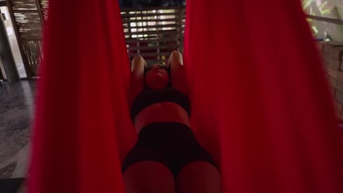 Young Woman Practicing Aerial Yoga in Studio