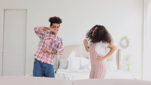 Young Couple Dancing Together in Bedroom
