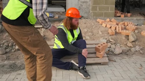 Worker suffering from leg pain resulting from an injury on a construction site