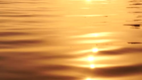 Sonnenuntergang an der Meeresoberfläche, niedriger Winkel, Blick über goldenes Meerwasser, Sonnenblendung, abstrakter nautischer Sommer