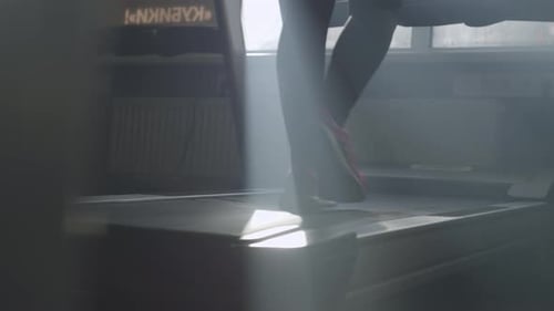 Closeup Slow Motion Video of Female Legs Running on a Treadmill in the Gym