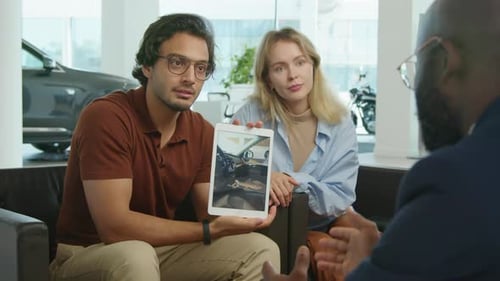 Vendedor e clientes discutindo o interior do carro