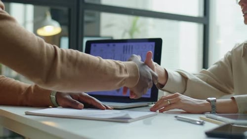 Colleagues Shaking Hands and Speaking in Office