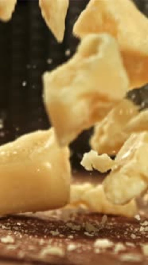Parmesan Cheese Falls on a Wooden Board Filmed on a Highspeed Camera at 1000 Fps