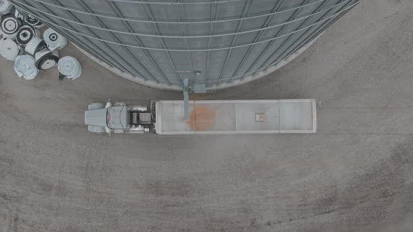 Drone footage of trucks semi loading corn at farmstead grain bin ...