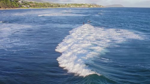drone footage moving along with the white capped blue ocean waves along the coast of Oahu Hawaii as
