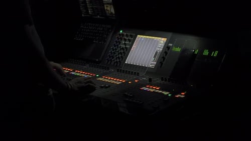Sound engineer working on mixing desk at a live concert at night. Music control dj technician.
