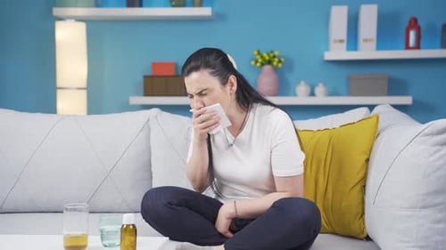 Woman with Cold Sitting on Couch at Home