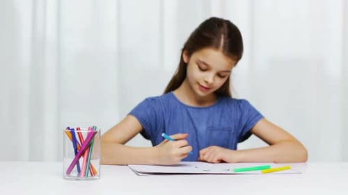 Girl drawing with colorful markers on white paper