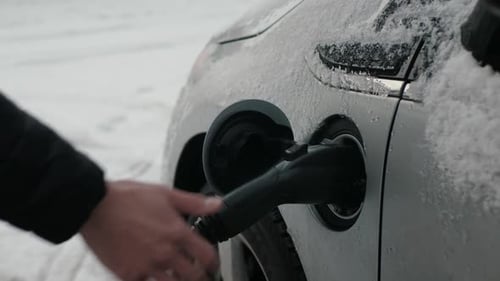 Plugging electric car charging cable in the winter