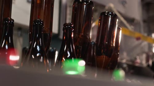 Brown Glass Bottles Upside Down on Filling Machine at Cider Production Factory