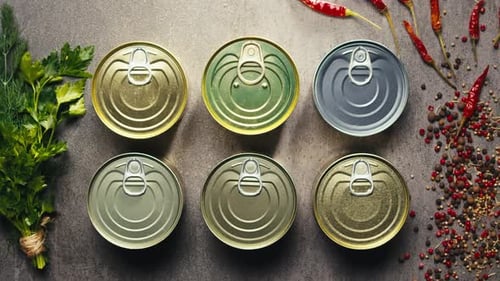 Latas de metal con comida enlatada o paté, vista desde arriba, latas doradas y plateadas con anillos para tirar, enlatadas