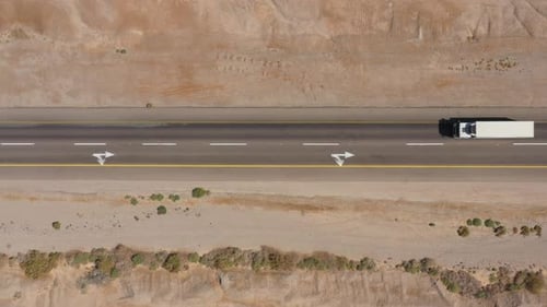 Cars driving on a Desert road surrounded by dry land, Aerial view