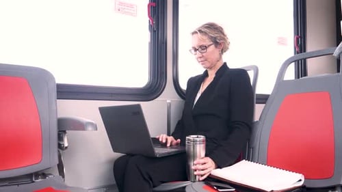 Geschäftsfrau arbeitet am Laptop im Bus des öffentlichen Nahverkehrs