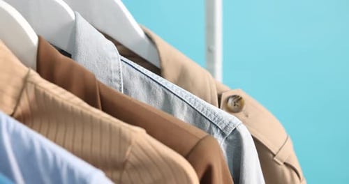 Stylish Shirts Hanging on White Hangers in Studio