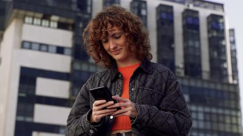 Casual Attractive Caucasian Woman Texting On Smartphone In The City