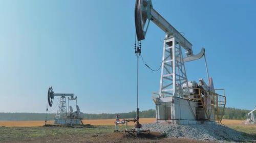 Pumping Rigs Extracting Oil From an Oil Well in Vast Oil Field Oil Industry Equipment