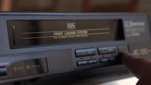 Deja de reproducir y expulsa la cinta de vídeo VHS de un reproductor vintage de los ochenta, de cerca