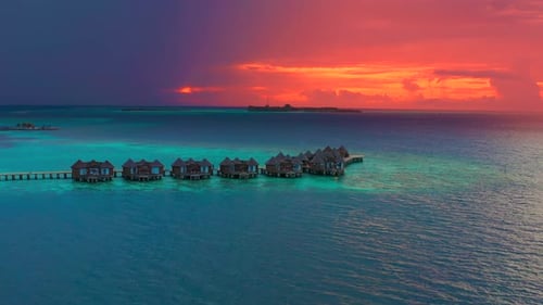 Overwater Villas at the Time Amazing Sunset in Tropical Sea with Coral Reef