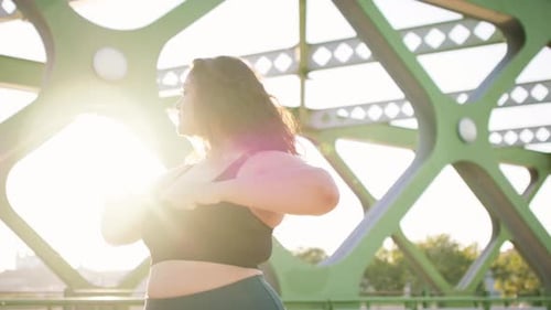 Closeup Shot Of Young Overweight Woman Exercising Outdoors In Bridge.