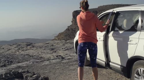 Victorious young woman celebrates achievement admiring breathtaking canyon view