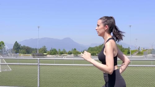 Woman Jogging On Sport Track At Stadium On A Sunny Day - tracking