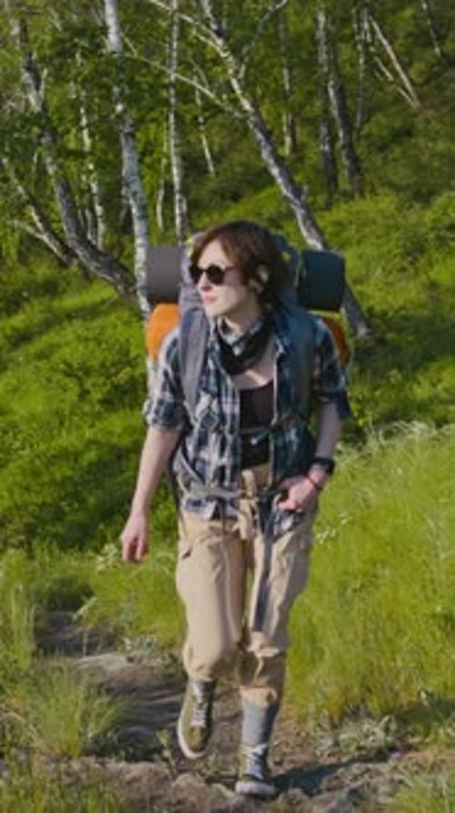 Vertical of Woman Walking up Hill during Summer Hiking Journey