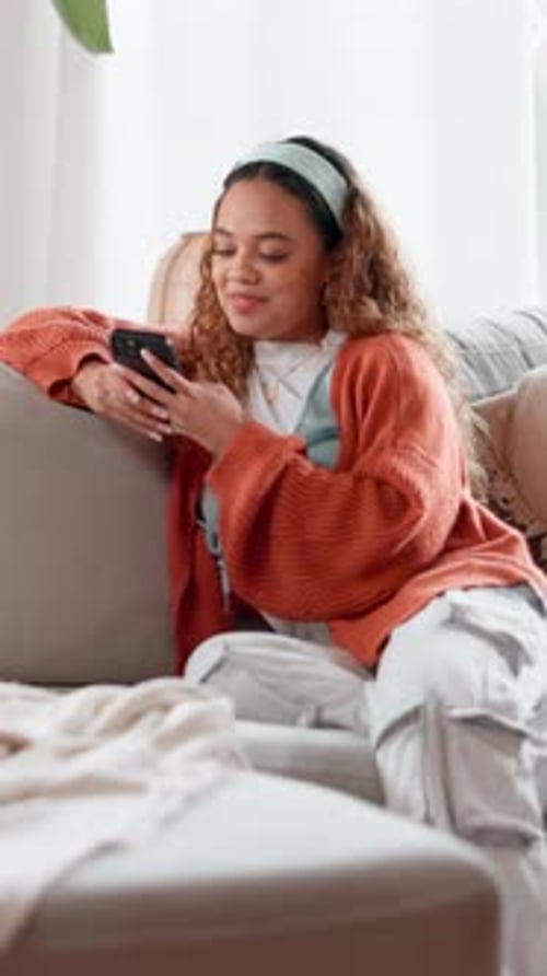 Woman Relaxes at Home, Texting on Mobile Device
