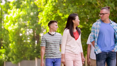 Group of friends walking in a sunny park