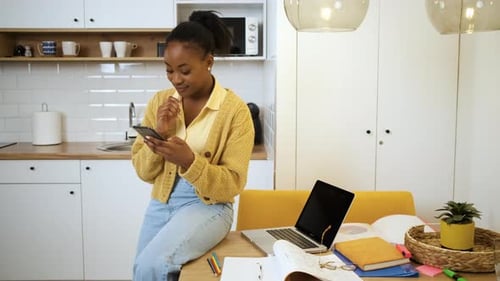 Young Woman Using Phone in Modern Kitchen