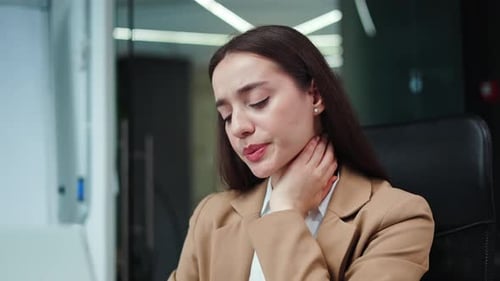 Business Woman Massaging Sore Neck in Office