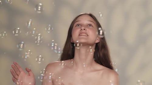 Woman Smiles and Plays with Soap Bubbles