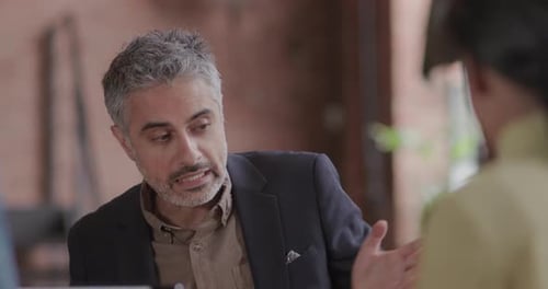 Business Meeting with Gesturing Man in Blazer