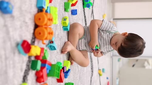 Infant Plays with Colorful Building Blocks at Home