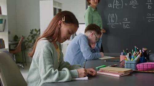 Children studying math with teacher in classroom
