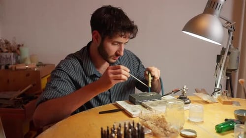 Der Ingenieur konzentriert sich auf die komplizierte Schmuckmontage in einem gut beleuchteten Arbeitsbereich.