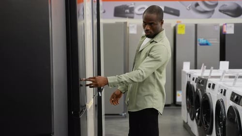 African American Customer Examining Refrigerator in Electronics Store