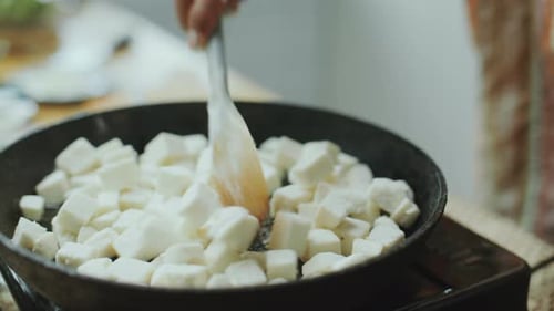 Stirring Cubes of Fresh Paneer with Spatula in Hot Frying Pan