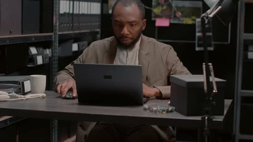 Adult at Desk Working on Laptop With Files
