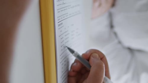 Unknown Woman Filling Form for Cosmetic Procedures at Clinic Vertical Close Up