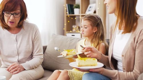 Three Generations Enjoying Cake Together Indoors